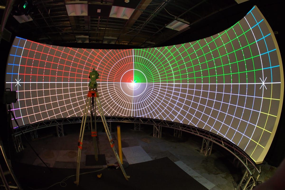 Color grid calibration pattern displayed on a curved screen during geometric warping