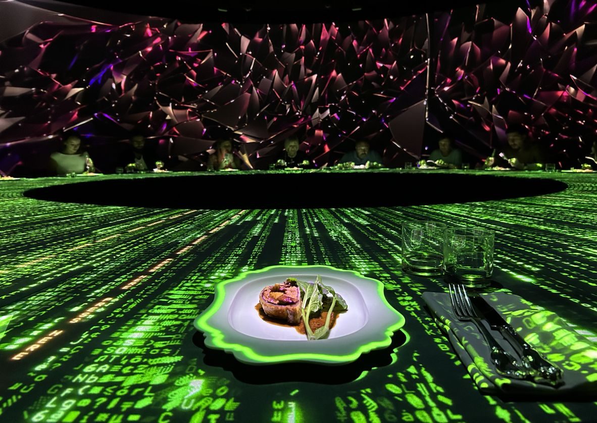 Projected green light effects flowing across a table as dishes arrive