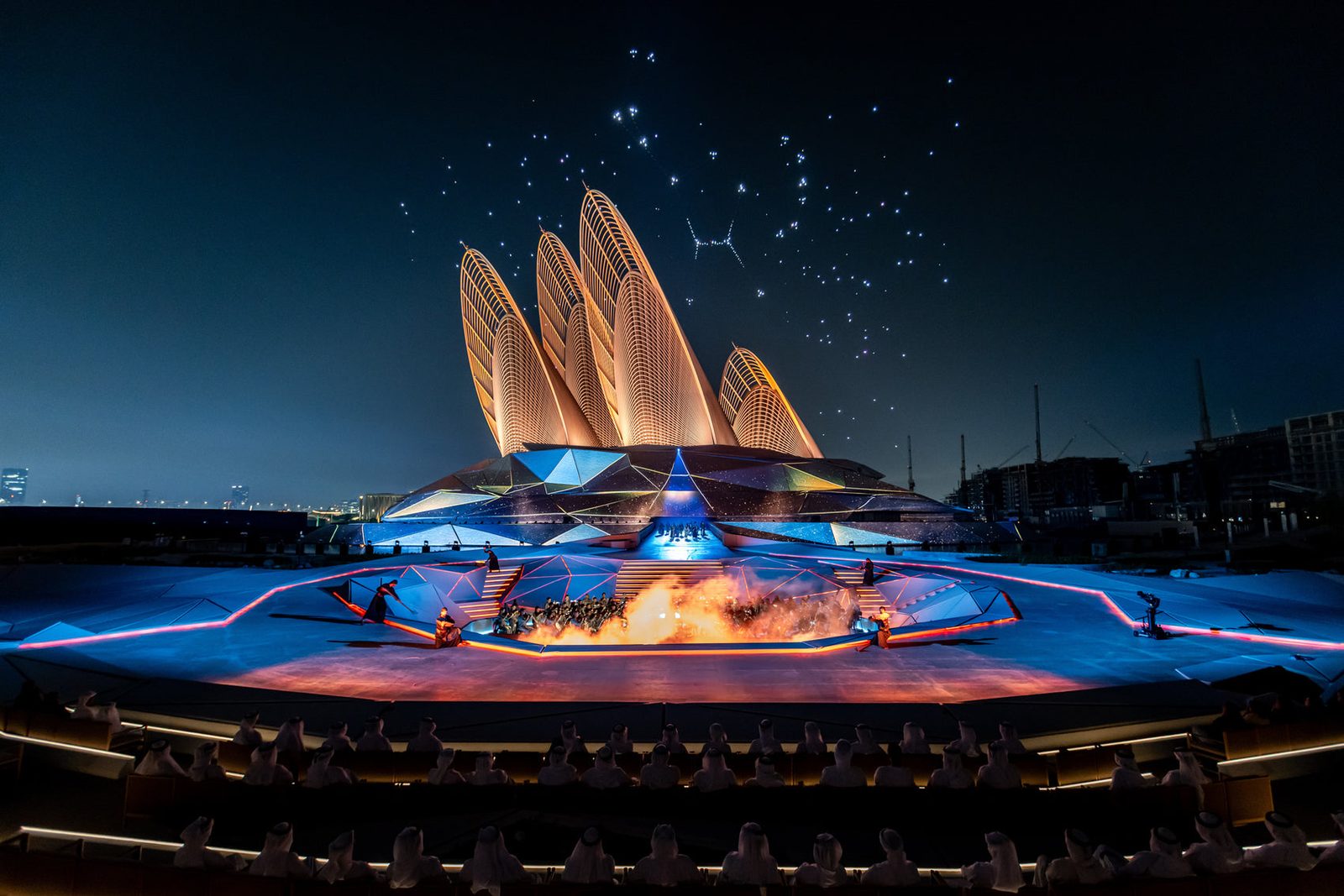 Petal-shaped building hosting a night light show with stage and fireworks