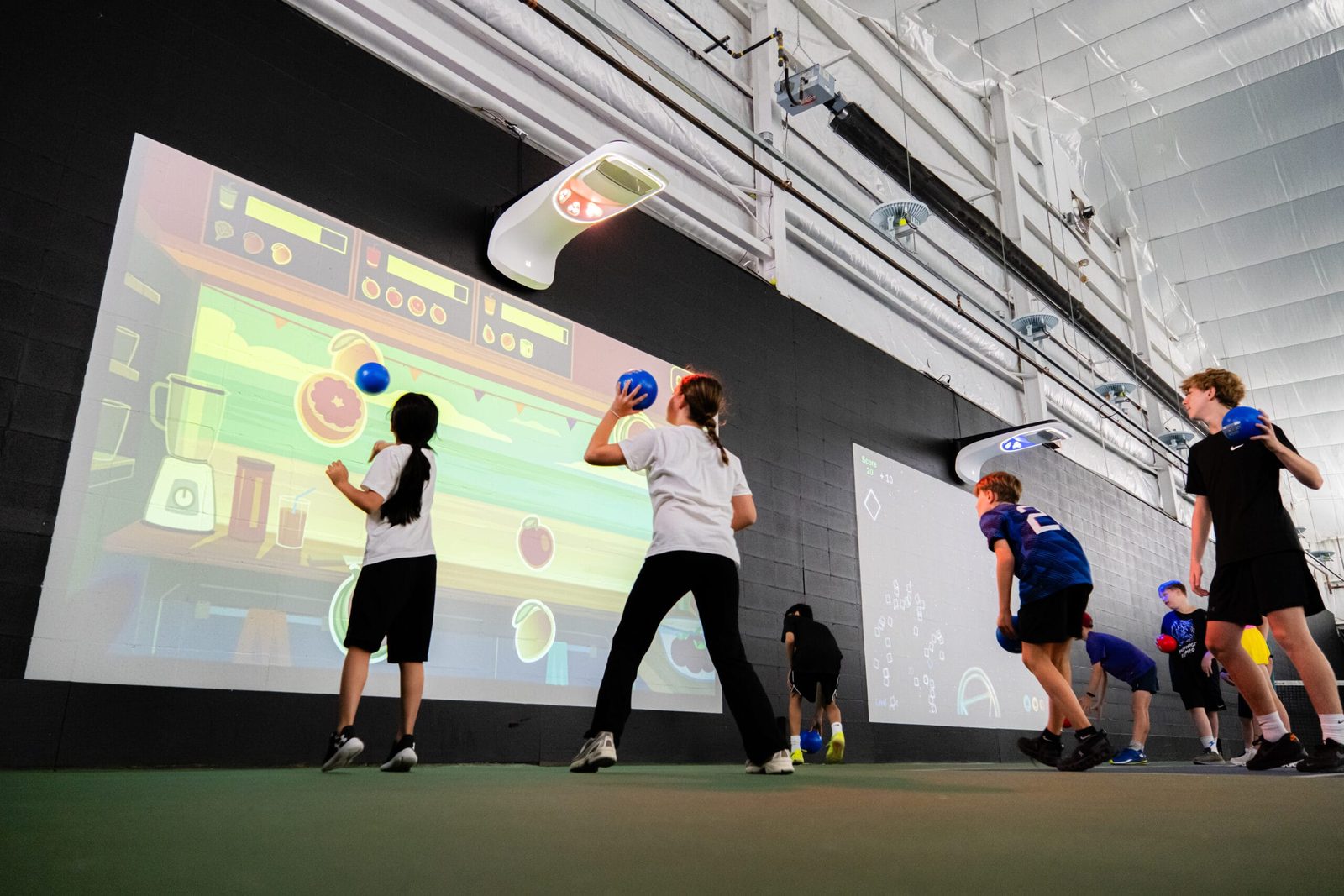 Children throwing ocean balls at an interactive projection smash wall