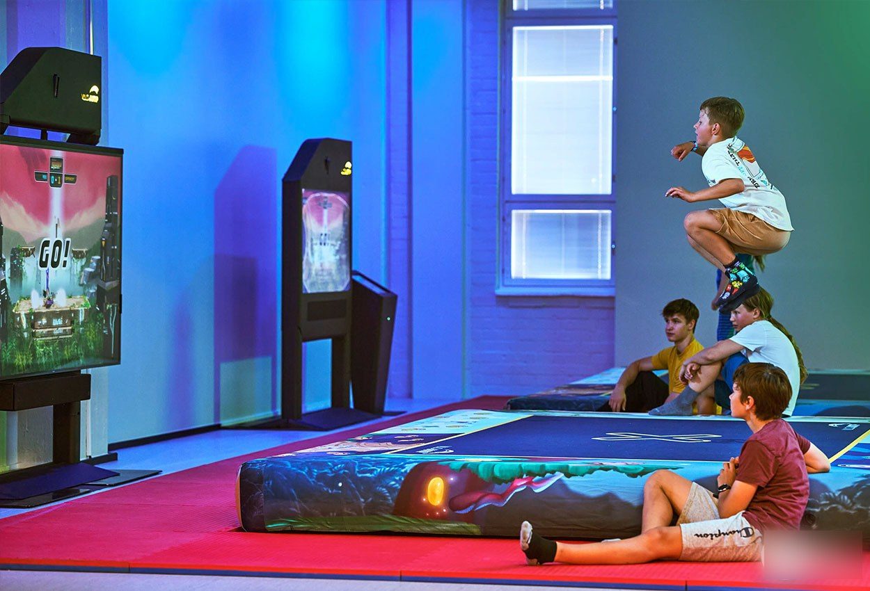Children playing on an interactive trampoline with a screen synced to their jumps