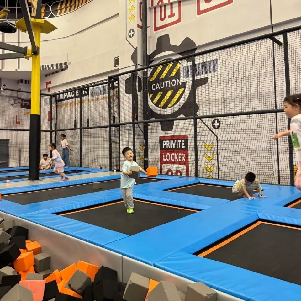 Kids queuing to replay an interactive game zone in a trampoline park